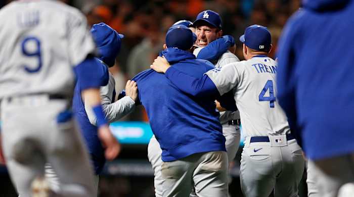 Oct 14, 2021; San Francisco, California, USA; Los Angeles Dodgers pitcher Max Scherzer (facing camera) is mobbed by teammates after defeating the San Francisco Giants in game five of the 2021 NLDS at Oracle Park.